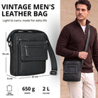 Small flat black leather crossbody bag for men, front and worn view by model, exterior pockets and size markings, fits 8 inch tablet