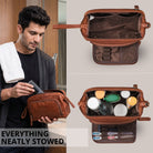 Maraska brown leather toiletry bag with open top showing interior compartments; lifestyle shot of man packing it in a bathroom.