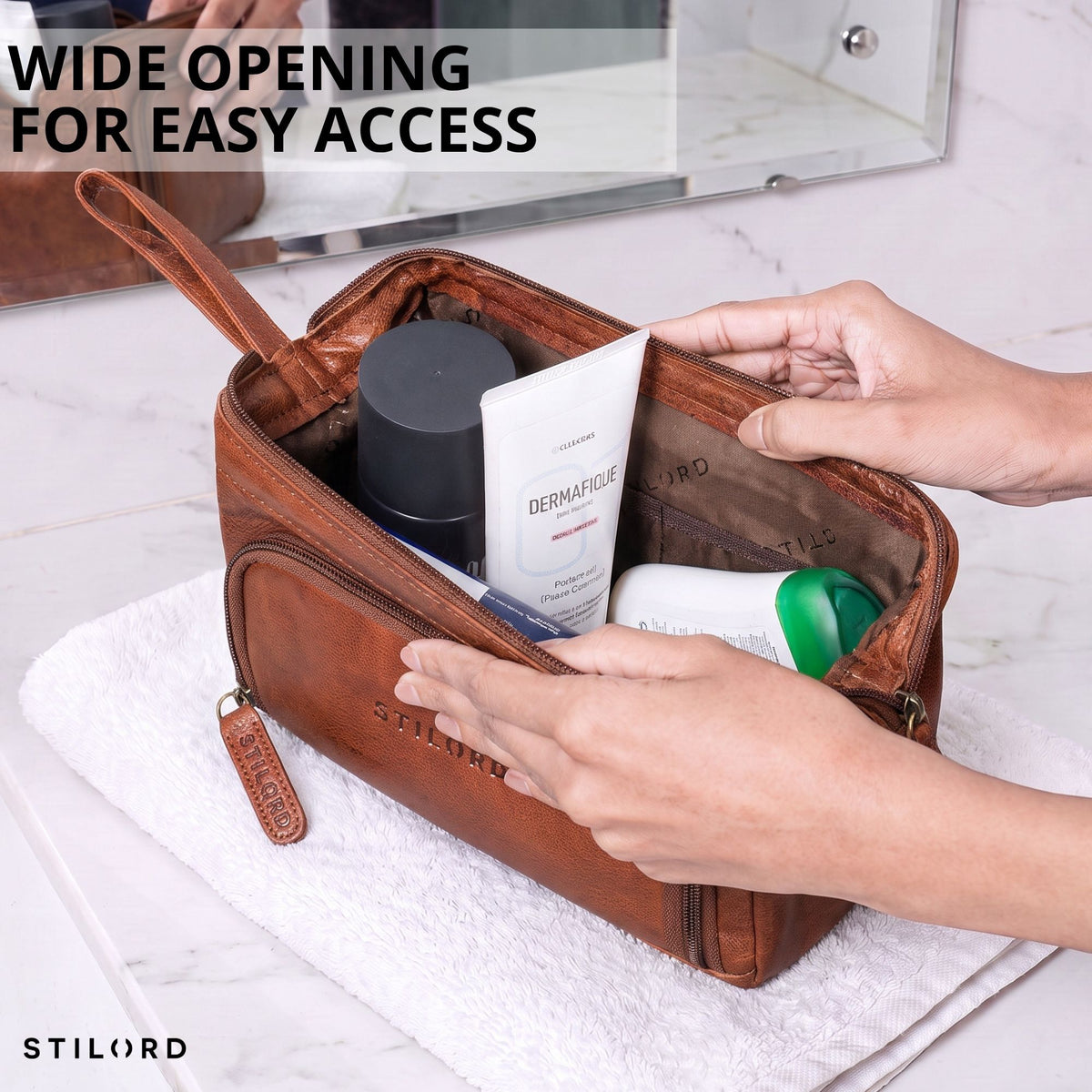 Leather toiletry bag maraska brown, wide-open view with hands accessing interior, STILORD logo visible