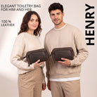 Leather toiletry bag in zamora brown, front view held by man and woman, STILORD embossing visible.